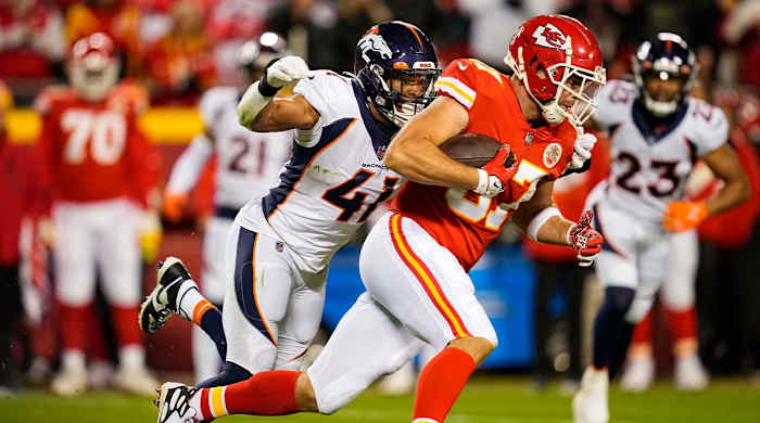 Dec 5, 2021; Kansas City, Missouri, USA; Kansas City Chiefs tight end Travis Kelce (87) runs the ball against Denver Broncos linebacker Kenny Young (41) during the second half at GEHA Field at Arrowhead Stadium.